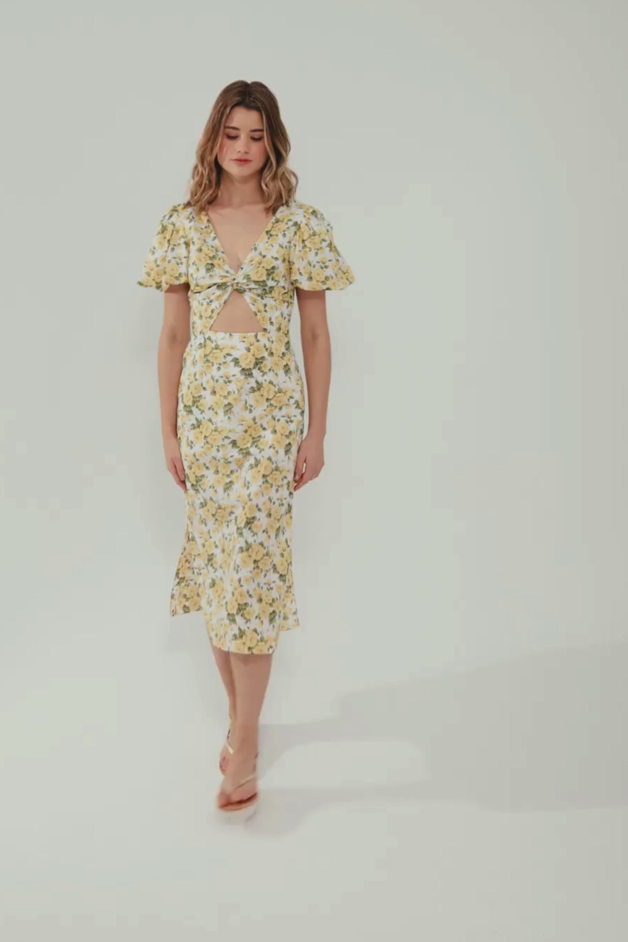 E-commerce video with a model waling in a white dress with yellow roses 